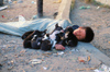 Myanmar - Mandalay: homeless boy sleeping with puppies - photo by W.Allgwer - In Waisenjunge schlft am Strassenrand mit seinen Hunden. Er hat sich zum Schutz vor Klte und Schmutz in einen Plastiksack gehllt. Das soziale Netz in Myanmar ist grobmaschig
