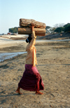 Myanmar - Mandalay: day labourer in the harbour carrying wood - photo by W.Allgwer - Eine junge Frau beim lschen der Ladung im Hafen von Mandalay. Vor allem die in die Stdte gezogene Landbevlkerung mu sich anfangs oft den Lebensunterhalt als Tagelhn