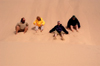 Namibia: Four people sliding down Roaring Sand Dunes, Skeleton Coast - photo by B.Cain