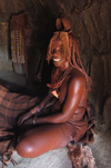 Namibia: Himba Woman sitting in hut, Skeleton Coast, Kunene region - photo by B.Cain