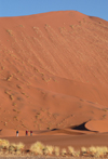 Namib Desert - Sossusvlei, Hardap region, Namibia, Africa:  tiny people at baseof enormous sand dune - photo by B.Cain