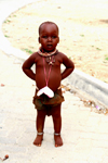 Kunene region, Namibia: Himba boy - travelling in the country with his mother - photo by Sandia