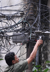 Kathmandu, Nepal: an electrician working in Katmandou street - chaotic wires - photo by E.Petitalot