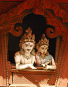 Kathmandu, Nepal: wood statues of royal couple at the window, in a pose similar to Shiva and Parvati, in a pagoda temple roof strut, near Durbar Square - photo by E.Petitalot