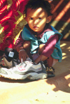 Pokhara, Nepal: toddler playing with adult shoe - photo by E.Petitalot