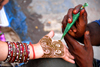 Kathmandu, Nepal: man applying henna pattern to a woman's hand - photo by J.Pemberton