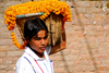 Kathmandu, Nepal: Pashupatinath Temple - man carrying a basket of marigolds - photo by J.Pemberton