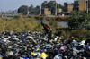 Kathmandu, Nepal: man searches in a garbage dump along the river - photo by W.Allgwer