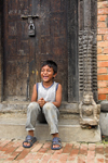 Patan, Lalitpur District, Bagmati Zone, Nepal: local boy sitting in carved doorway - photo by J.Pemberton