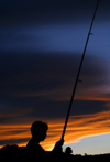 New Zealand - silhouette of a man fishing (photographer: Mark Duffy)