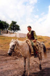 Nagorno Karabakh - Dirimbon: rough rider - cowboy, Caucasus style - war memorial in the background (photo by M.Torres)