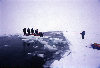 Arctic Ocean: using a block of ice as a raft to cross a lead of open water - North Pole expedition (photo by Eric Philips)