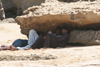 Karachi, Sindh, Pakistan: men resting under rocks - while waiting for customers at the French Beach - the shade - photo by R.Zafar