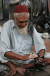 Karachi, Sindh, Pakistan: old man polishing a customer's shoes - photo by R.Zafar