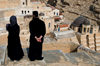 Mar Saba Monastery, West Bank, Palestine:  Greek Orthodox monk and female visitor overlooking the monastery - Great Lavra of St. Sabas - photo by J.Pemberton