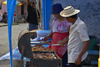A man and a woman grill some meat for vending - Portobello, Coln, Panama - photo by H.Olarte