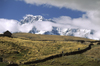 Ausangate massif, Cuzco region, Peru: hikers cross a farm on the high Altiplano below the mighty Andean peak of Ausangate - Peruvian Andes - Cordillera Blanca - photo by C.Lovell