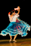 Lima, Peru: young woman dancer turning on a stage in Lima - Peruvian ethnic clothing with a flowing blue skirt and pink handkerchief - photo by D.Smith