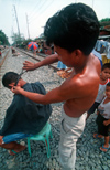 Manila city, Philippines - haircut on the railway tracks - Slums and shanty towns - photo by B.Henry