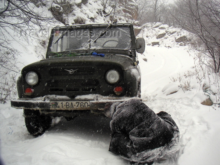 azer160: Azerbaijan - outside Quba: snow chains being put on a UAZ jeep - road to to Xiniliq (photo by Austin Kilroy) - (c) Travel-Images.com - Stock Photography agency - Image Bank