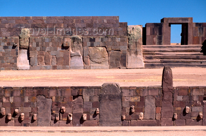 bolivia131: Tiwanaku / Tiahuanacu, Ingavi Province, La Paz Department, Bolivia: Semi-Underground Temple with carved enemy heads – Kalasasaya temple gate in the background - photo by C.Lovell - (c) Travel-Images.com - Stock Photography agency - Image Bank