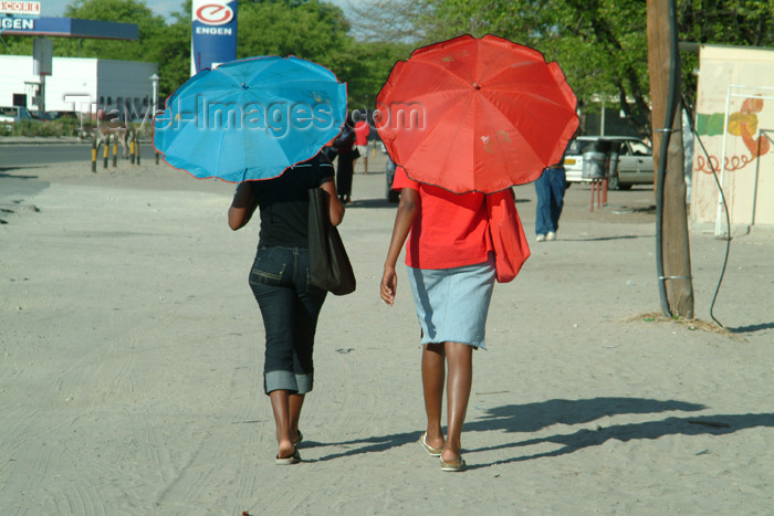 botswana15: Maun, North-West District, Botswana: covering from the sun - two women walk with umbrellas - photo by J.Banks - (c) Travel-Images.com - Stock Photography agency - Image Bank