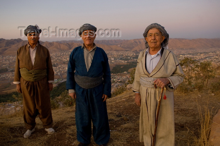 iraq102: Duhok / Dohuk / Dehok / Dahok, Kurdistan, Iraq: three Kurdish men in traditional attire in the cliffs above the city - baggy pantaloons, a shirt, a cummerbund in which valuables and daggers are kept and a close-fitting turbanlike head wrap - Cilî Kurdî - photo by J.Wreford - (c) Travel-Images.com - Stock Photography agency - Image Bank