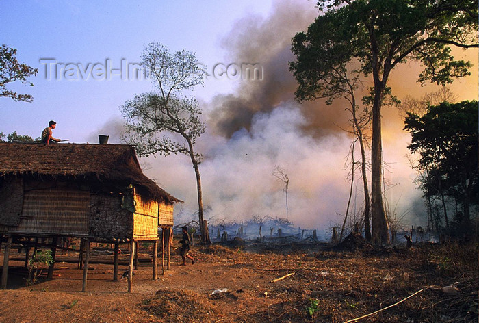 laos102: Laos: forest fire - a man is on the roof of his house with a bucket of water against the fire
 - photo by E.Petitalot - (c) Travel-Images.com - Stock Photography agency - Image Bank
