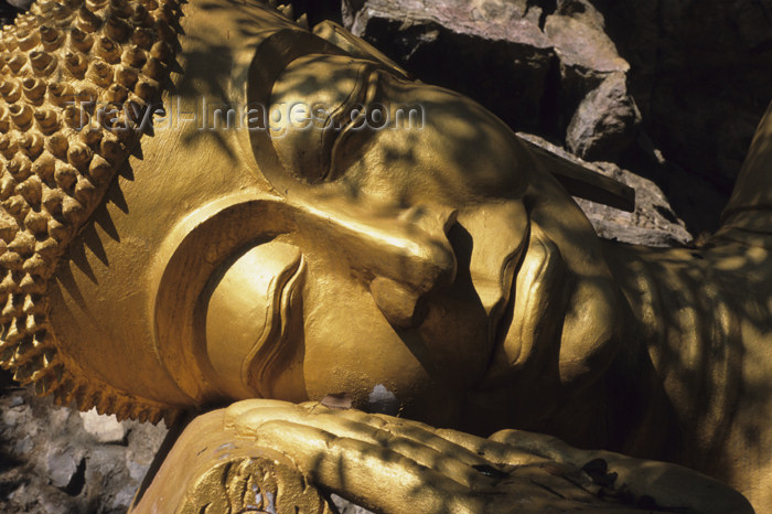 laos93: Ruhender Buddha: Der Buddha liegt auf seiner rechten Seite. Die rechte Hand unterstützt den Kopf, während die linke Hand ausgestreckt an seiner linken Seite liegt. Beide Füße liegen symmetrisch und parallel. Normalerweise ruht die rechte Schulter auf dem  - (c) Travel-Images.com - Stock Photography agency - Image Bank