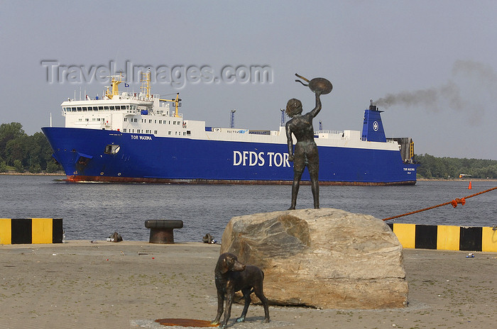 lithuania206: Klaipeda, Lithuania: bronze sculpture of a boy and dog meeting ships - a ferry enters the harbour - Tor Maxima - photo by A.Dnieprowsky - (c) Travel-Images.com - Stock Photography agency - Image Bank