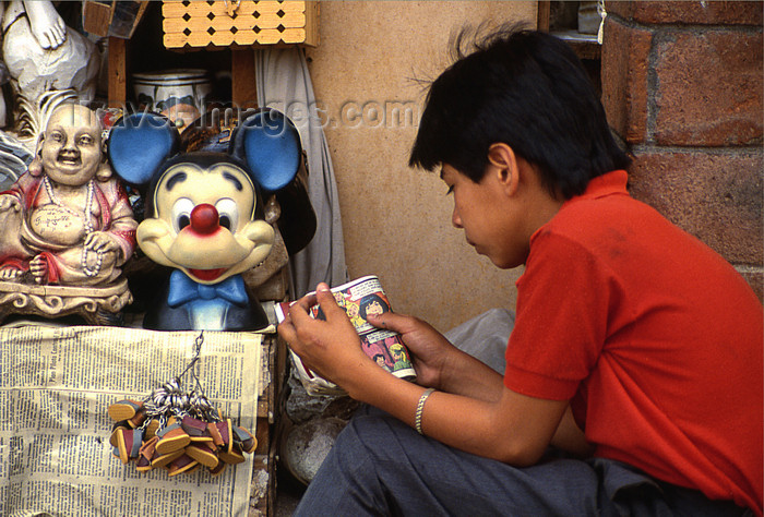 mexico361: Guanajuato City: boy reading comics book - Buddha and MIckey Mouse - photo by Y.Baby - (c) Travel-Images.com - Stock Photography agency - Image Bank