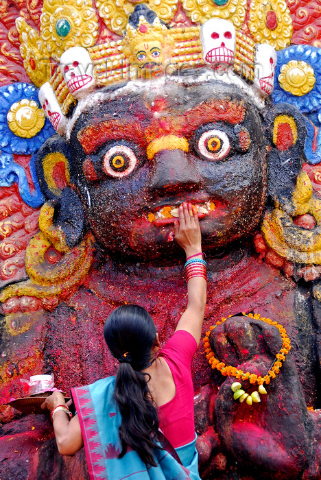 nepal216: Kathmandu, Nepal: woman making a food offer to Kala Bhairava, ferocious manifestation of Shiva associated with annihilation - Hanuman Dhoka, Durbar square - photo by J.Pemberton - (c) Travel-Images.com - Stock Photography agency - Image Bank