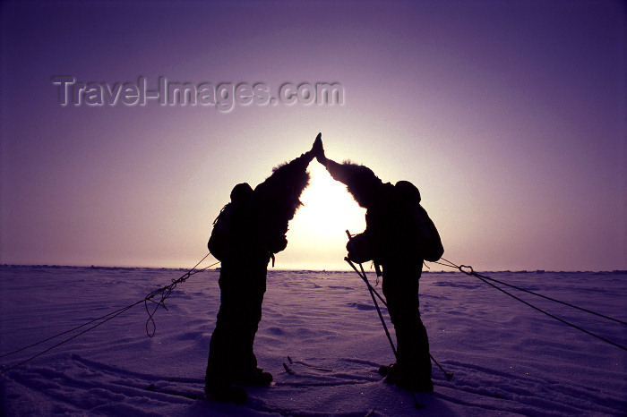 north-pole2: North Pole: celebrating a successful expedition - silhouettes and sun in the North Pole - two skiers - Severní pól, Nordpolen,Polo Norte, Pôle Nord, Polo Nord, Noordpool, Polul Nord (photo by Eric Philips) - (c) Travel-Images.com - Stock Photography agency - Image Bank