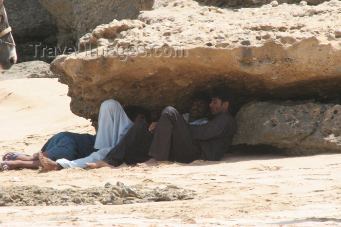 pakistan76: Karachi, Sindh, Pakistan: men resting under rocks - while waiting for customers at the French Beach - the shade - photo by R.Zafar - (c) Travel-Images.com - Stock Photography agency - Image Bank