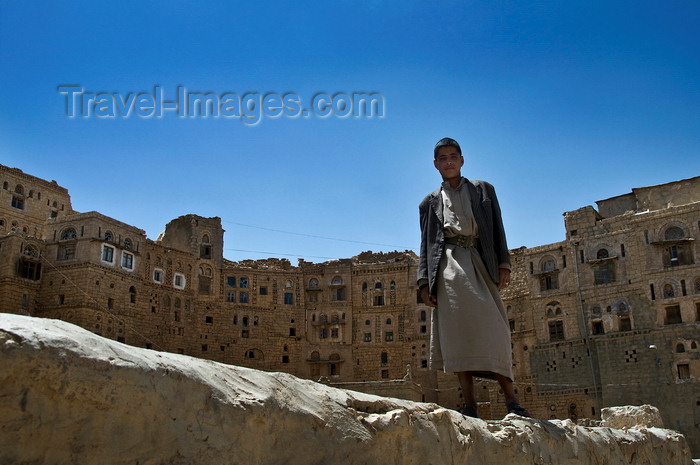 yemen105: Hababah, Sana'a governorate, Yemen: young man standing on wall in front of Old Town buildings - photo by J.Pemberton - (c) Travel-Images.com - Stock Photography agency - Image Bank