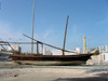 Doha, Qatar: fishing dhow on land  - Al-Khoot Fort in the background - Dhow Round About - photo by B.Cloutier