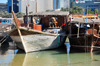 Doha, Qatar: prow view of dhows in the Dhow harbour - Corniche in the background - Qatar National Bank building - photo by M.Torres
