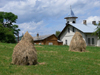 Gura Humorului, Suceava county, southern Bukovina, Romania: haystacks, chapel and rural houses - photo by J.Kaman
