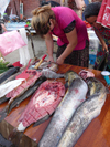 Chechnya, Russia - Grozny - fishmonger stall - Chechen woman cuts the fish in market - photo by A.Bley