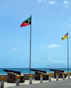 Charlestown, Nevis, St Kitts and Nevis: old British naval guns aimed at the sea on Low Street, country and island flags - photo by M.Torres