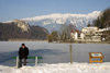 Slovenia - men on bench - view across Lake Bled in Slovenia when frozen over in winter - Karavanke mountain range - photo by I.Middleton