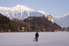 Slovenia - a woman walks across Lake Bled when frozen over in winter - photo by I.Middleton