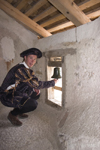 Tour guide ringing wishing bell of Predjama Castle , Slovenia - photo by I.Middleton