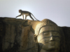 Polonnaruwa, North Central province, Sri Lanka: monkey atop head of stone carved Buddha - photo by B.Cain