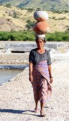 Woman in abandoned salt fields with water jugs