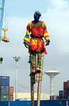 Lom, Togo: man on stilts in the port - crane, water tower and containers in the background - Port Autonome de Lom - photo by G.Frysinger