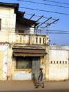 Lom, Togo: woman walks in front of an old colonial building - photo by G.Frysinger