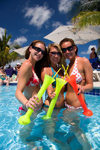 Grand Turk Island, Turks and Caicos: three young women wearing bikinis drinking tall margaritas in the pool at Jimmy Buffet's Margaritaville bar and restaurant - photo by D.Smith