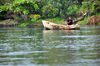 Jinja, Uganda: man on a wooden canoe - source of the Nile river, western bank - photo by M.Torres