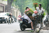 Hanoi - vietnam - flower vendor on bike and client on a scooter - photo by Tran Thai